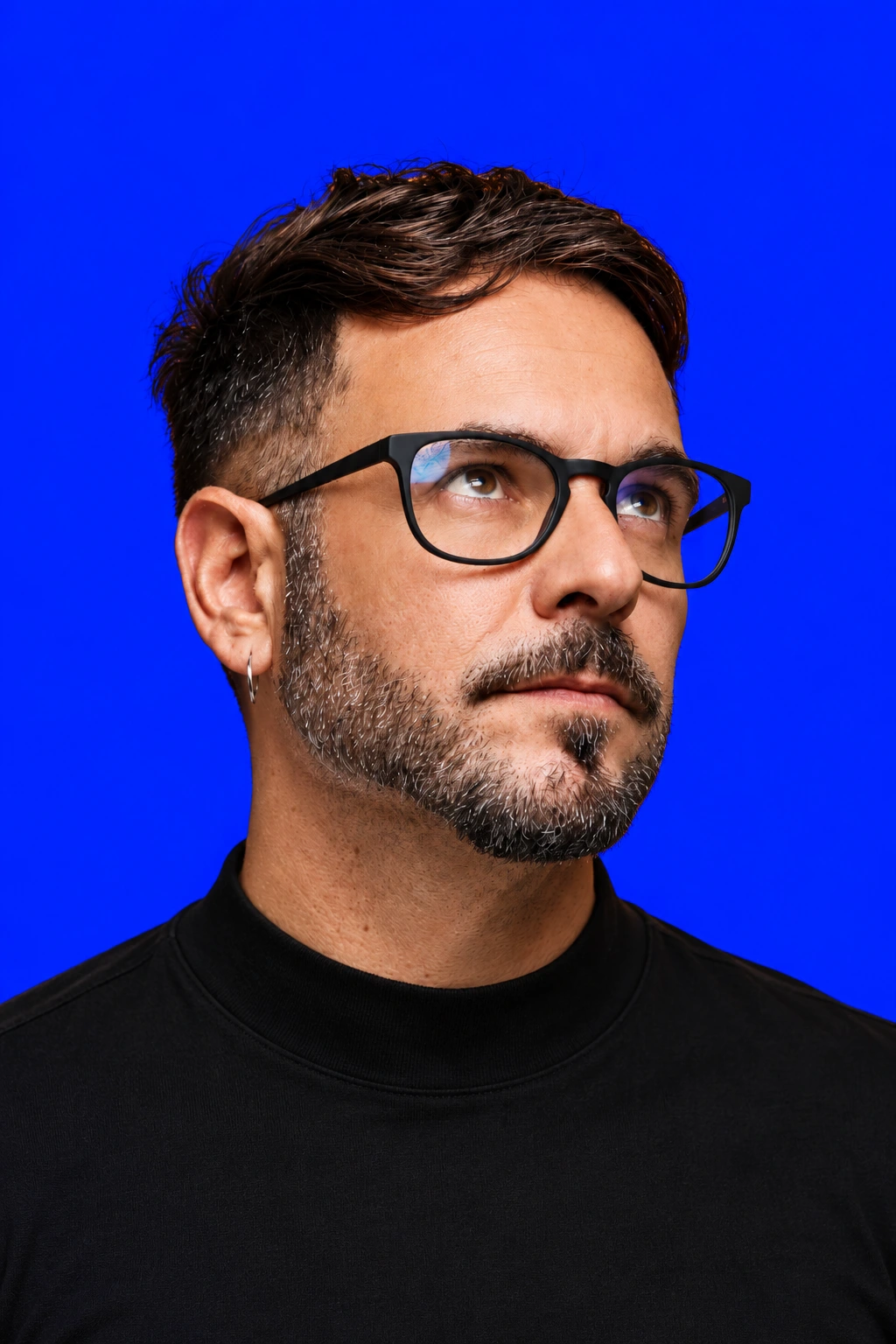 Luiz Parpulov de óculos sobre fundo azul / Luiz Parpulov wearing glasses against a blue background